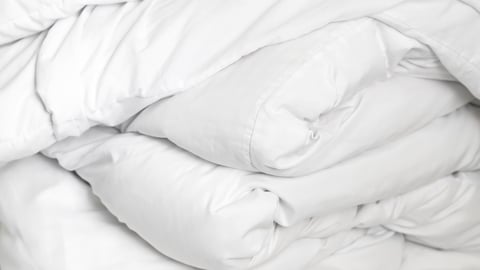 Clean bedding setup representing hotel rest minimalism and daily wellness