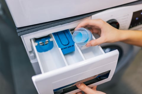 Woman puts softener in the washing machine